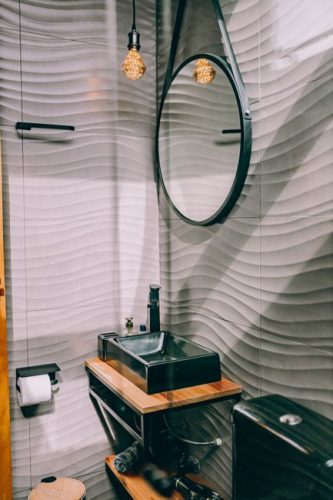 Elegant modern bathroom with wooden accents and unique lighting.
